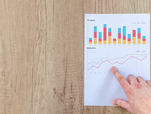 A hanrd pointing to charts on paper