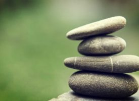 Four flat rocks balancing on top of one another